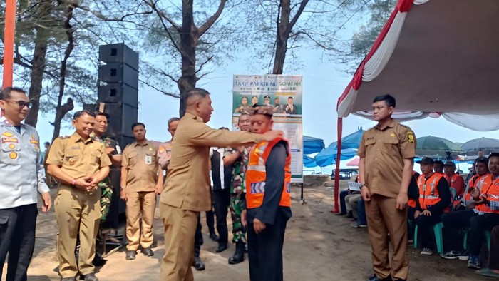 Wabup Andreas memakaikan atribut ke petugas parkir di launching Parkir Someah