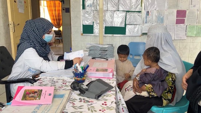 Sadiqa, 30, from Helmand, collects packets of fortified nutritional food for her children, at a clinic in Helmand, Afghanistan, July 14, 2026, in this still image taken from a handout video. WFP/Handout via REUTERS    THIS IMAGE HAS BEEN SUPPLIED BY A THIRD PARTY. MANDATORY CREDIT.