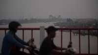 Pengendara motor melintasi Jembatan Musi VI dengan latar Sungai Musi yang diselimuti kabut asap di Palembang, Sumatera Selatan, Rabu (5/8/2026).