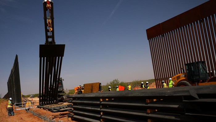 Construction workers operate machinery as they build a secondary section of the black-colored border wall along the U.S.-Mexico border, as seen from Ciudad Juarez, Mexico, August 5, 2026. REUTERS/Jose Luis Gonzalez