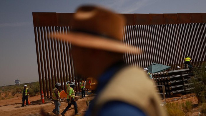 Construction workers operate machinery as they build a secondary section of the black-colored border wall along the U.S.-Mexico border, as seen from Ciudad Juarez, Mexico, August 5, 2026. REUTERS/Jose Luis Gonzalez