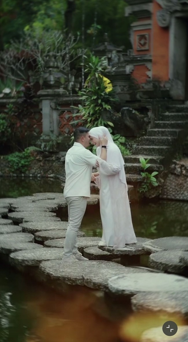 Irish dan Haldy tampil kompak dalam balutan busana bernuansa putih. Irish memadukan dress panjang putih dengan outer warna pink pastel yang soft. Sementara Haldy tampil dengan kemeja putih lengan pendek dipadukan celana panjang warna coklat muda. Foto: Instagram/@_irishbella_