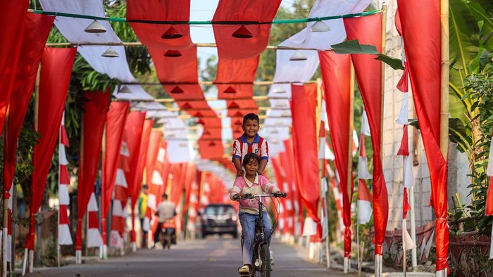 Foto udara seorang anak bersepeda di bawah bendera Merah Putih yang terbentang di Kampung Peundeuy Timur, Desa Karang Satu, Kecamatan Karangbahagia, Kabupaten Bekasi, Jawa Barat, Kamis (6/8/2026). Warga setempat membentangkan bendera Merah Putih sepanjang 500 meter yang dibuat secara gotong royong dengan biaya swadaya sekitar Rp25 juta untuk menyambut HUT ke-81 Kemerdekaan RI. ANTARA FOTO/Darryl Ramadhan/kye