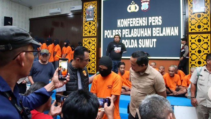 Petugas kepolisian saat menginterogasi pelaku penganiayaan di Medan