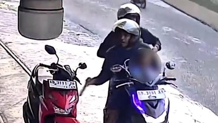Pria mencuri HP di dasbor motor parkir saat memboncengkan anak dan istrinya di Kasihan, Bantul, Kamis (6/8/2026).