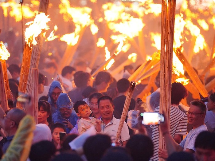 XINYU, CHINA - AUGUST 06: Tourists hold torches during a parade at the 2026 Hushan Duzeli Tangxia Yi Torch Festival on August 6, 2026 in Xinyu, Jiangxi Province of China. The torch festival is a traditional celebration of the Yi ethnic group, usually held around the 24th day of the sixth month on the Chinese lunar calendar each year. (Photo by Liu Lixin/China News Service/VCG via Getty Images)