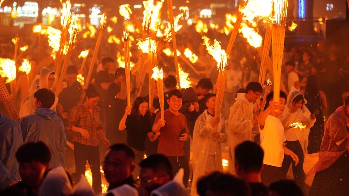 XINYU, CHINA - AUGUST 06: Tourists hold torches during a parade at the 2026 Hushan Duzeli Tangxia Yi Torch Festival on August 6, 2026 in Xinyu, Jiangxi Province of China. The torch festival is a traditional celebration of the Yi ethnic group, usually held around the 24th day of the sixth month on the Chinese lunar calendar each year. (Photo by Liu Lixin/China News Service/VCG via Getty Images)
