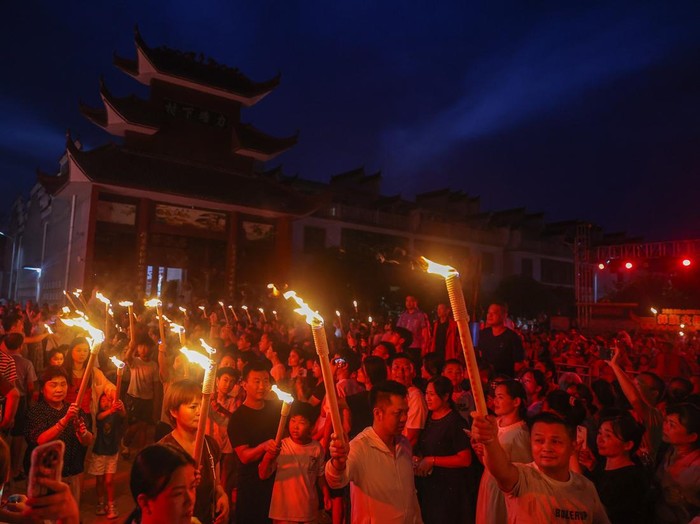 XINYU, CHINA - AUGUST 06: Tourists hold torches during a parade at the 2026 Hushan Duzeli Tangxia Yi Torch Festival on August 6, 2026 in Xinyu, Jiangxi Province of China. The torch festival is a traditional celebration of the Yi ethnic group, usually held around the 24th day of the sixth month on the Chinese lunar calendar each year. (Photo by Liu Lixin/China News Service/VCG via Getty Images)