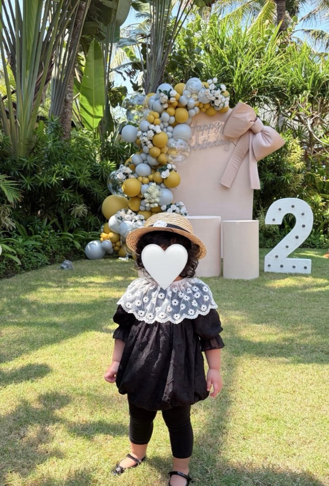 Meski wajahnya tertutup stiker, namun terlihat bahwa putri Syahrini memiliki rambut hitam yang ikal. Kenakan outfit serba hitam, penampilan Baby Princess R tampak menggemaskan. Foto: Instagram/@princessyahrini