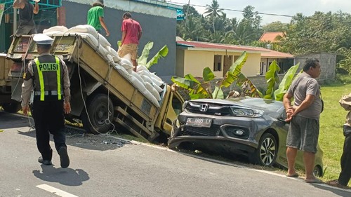 Mobil dan truk terperosok ke parit di pinggir jalan seusai tabrakan di Jalan Raya Sangeh - Gerana, Sabtu (8/8/2026). (Polres Badung)