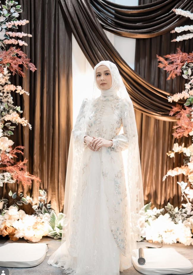 Dea mengenakan busana dari Zall Modiste by ASRI. Gamis panjang berwarna putih itu dilengkapi dengan motif bunga-bunga kecil bernuansa pastel seperti biru muda dan beige. Foto: Instagram/@deaaannisa
