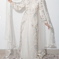 Bagian depan gamis dihiasi detail bordir serta ornamen floral yang memberikan kesan mewah. Siluet busana tampak mengikuti bentuk tubuh di bagian atas, kemudian jatuh panjang hingga menyentuh lantai. Foto: Instagram/@deaaannisa
