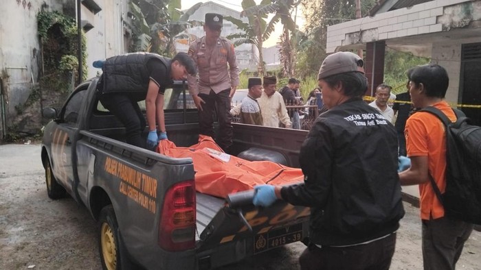 Polisi saat mengevakuasi jasad lansia yang ditemukan tewas depan kontrakan