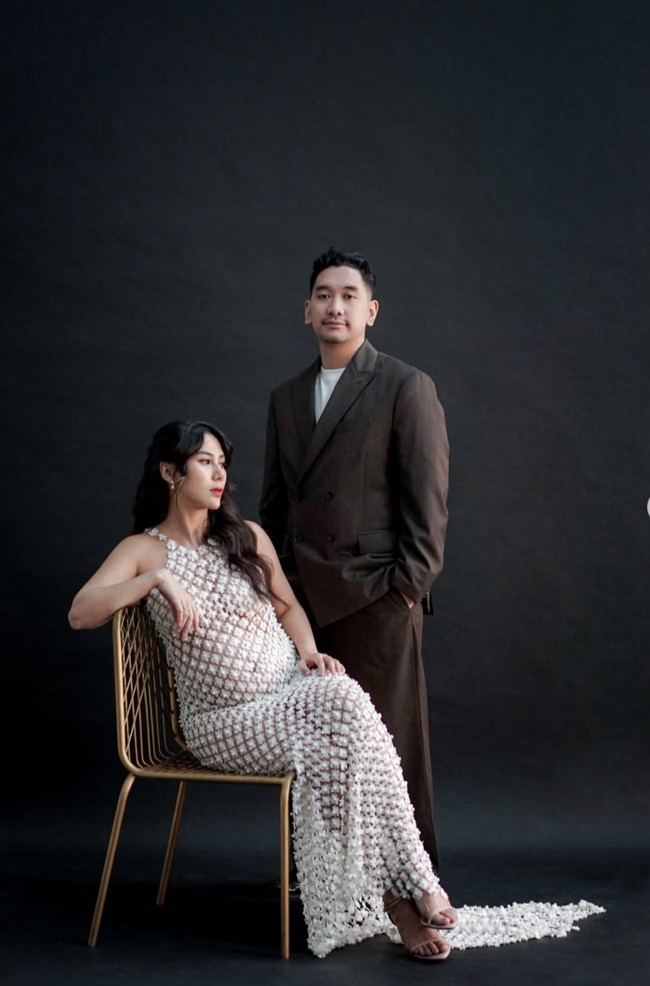 Penampilan Adinda Thomas di pemotretan maternity terbaru curi atensi. Adinda tampil seksi pakai dress putih, sementara suaminya, Raka Akmal, kenakan setelan blazer berwarna coklat gelap. Penampilannya terlihat santai dipadukan dengan kaos putih. Foto: Instagram/@adindathomas