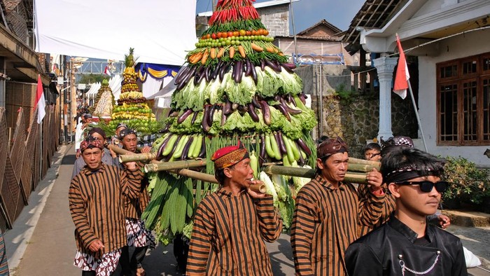 Sejumlah warga mengusung gunungan hasil bumi saat kirab  Festival Lembutan #7 di kawasan lereng Gunung Sindoro, Gentingsari, Bansari, Temanggung, Jawa Tengah, Sabtu (8/8/2026). Petani tembakau setempat menggelar Festival Lembutan yang mengangkat tema 