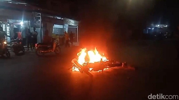 Sebuah motor dibakar saat konvoi yang berlangsung di Kecamatan Mariso, Kota Makassar.