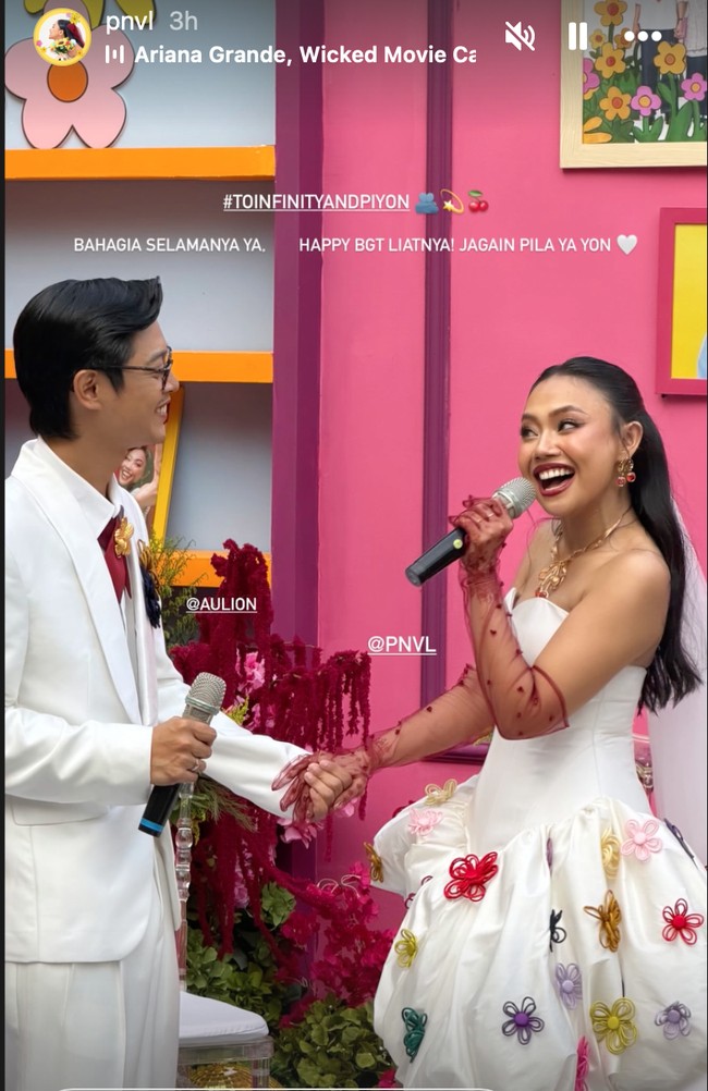 Pila tampil dengan mini dress putih dihiasi aplikasi bunga 3D warna-warni. Penampilannya semakin lengkap dengan sarung tangan transparan panjang warna merah marun yang senada dengan anting serta warna batu pada kalung emas yang dikenakannya. Foto: Instagram/@pnvl