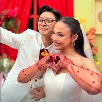 Riasan wajah Pila dibuat natural dipadukan dengan lipstik merah yang lebih bold. Serasi dengan Pila, Aulion juga menambahkan dasi merah maron untuk melengkapi setelan serba putih yang dikenakannya. Foto: Instagram/@pnvl