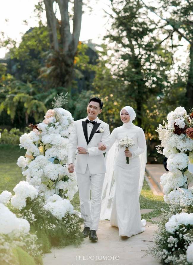 Pernikahan Dea dan Mazaki didominasi warna putih yang memberi kesan clean dan elegan. Kedua mempelai juga tampil serasi dalam balutan busana pengantin simpel. Foto: Instagram/@deaaannisa
