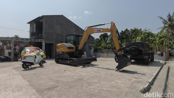 Penampakan mahar alat berat dan sejumlah kendaraan terparkir di halaman sisi timur rumah mempelai wanita wilayah Dusun Larangan, Ketro, Karangrayung, Grobogan, Senin (10/8/2026).