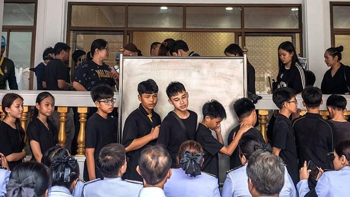 Para pelayat berkumpul sebelum doa untuk Naphat Chaima, korban penembakan sekolah berusia 12 tahun, di kuil Buddha Wat Lat Pla Duk, Provinsi Nonthaburi, Thailand, Minggu (09/08). (AFP via Getty Images)