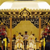 Saat pesta pernikahan, Raabiatul tampil mengenakan sepatu berhiaskan kristal rancangan desainer ternama Christian Louboutin. Selain itu, hijabnya dihiasi tiara bertahtakan berlian dan enam batu permata zamrud pinjaman dari Ratu Saleha, serta membawa buket bunga yang terbuat dari permata. Foto: REUTERS