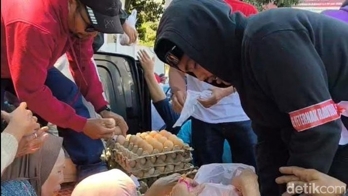 Peternak ayam bagi-bagi telur saat aksi damai di Jalan Urip Sumoharjo Makassar.