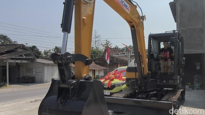 Rico Putra Roberto Syah (23) mengemudikan alat berat yang diberikan sebagai mahar kepada istrinya, Senin (10/8/2026).