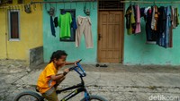 Seorang anak bermain di halaman kontrakan kawasan Bekasi, Senin (10/8/2026).