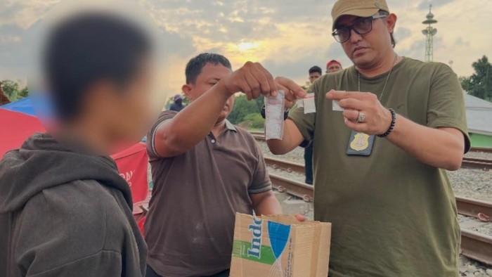 Petugas kepolisian saat menangkap pelaku.