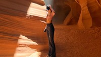 Potret paling estetis di mana Lisa berdiri tepat di bawah sorotan sinar matahari yang menembus celah tebing Antelope Canyon.  (Foto: dok Instagram lalalalisa_m)