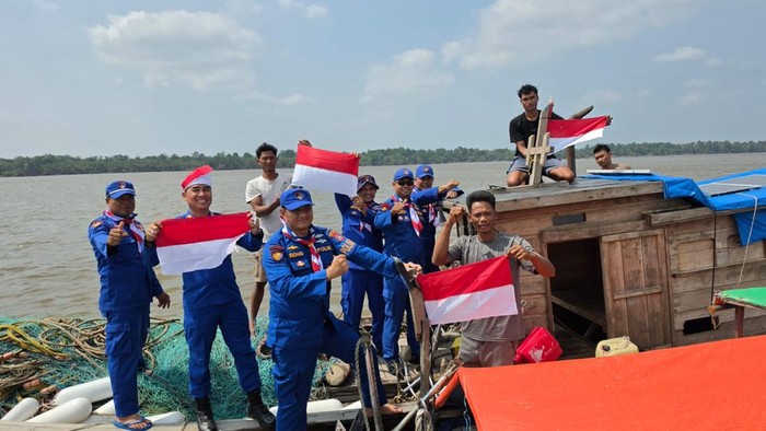 Tim Ekspedisi Merah Putih Satpolairud Polres Pelalawan menyapa nelayan dan membagikan bendera, Senin (10/8/2026).