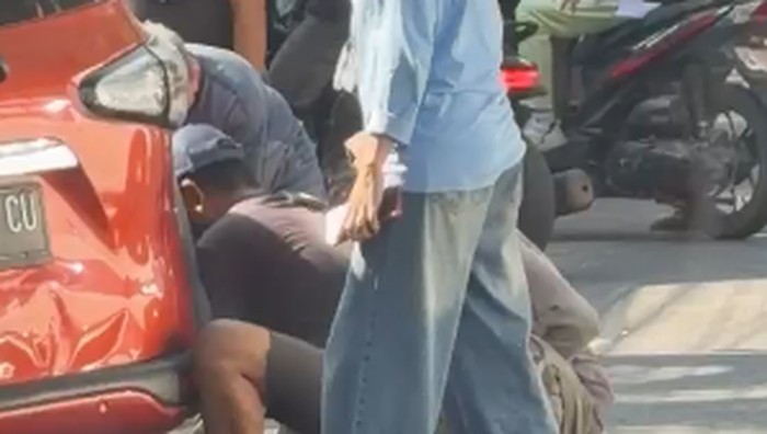 Pemobil dan jukir membongkar paksa gembok saat mobil ditindaki karena parkir bahu jalan di Jalan Veteran, Makassar.