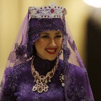 Pada bagian kepala, Raabiatul juga mengenakan veil transparan dengan tiara kedua yang dihiasi berlian, rubi, dan batu berwarna merah di bagian tengah. Ia melengkapi penampilan dengan kalung model rope yang juga bertabur berlian. Foto: dok. Reuters