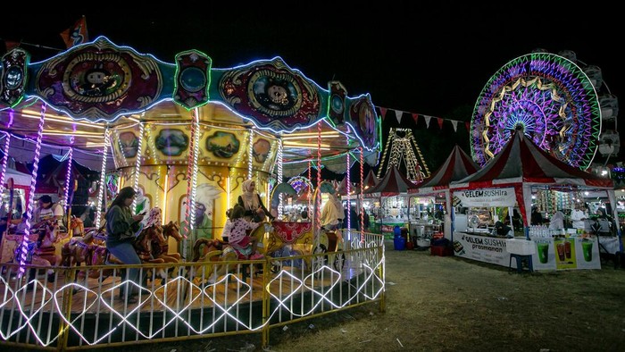 Warga bersama anaknya menaiki wahana permainan Pasar Malam Sekaten di Solo, Jawa Tengah, Selasa (11/8/2026). Pasar malam yang digelar selama sebulan penuh tersebut menjadi pembuka rangkaian tradisi tahunan perayaan Sekaten Keraton Kasunanan Surakarta dalam menyambut peringatan Maulid Nabi Muhammad SAW dan diharapkan dapat meningkatkan kunjungan wisata di Kota Solo dan mampu menggerakaan ekonomi pelaku UMKM lokalANTARA FOTO/Mohammad Ayudha/bar