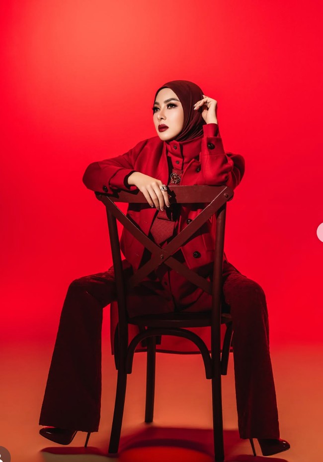 Senada dengan busana yang dikenakan, riasan Syahrini juga dibuat bold dengan lipstik merah. Makeup terlihat glamor dengan complexion yang halus dan matte. Bagian mata dibuat cukup intens menggunakan eyeliner dan bulu mata yang lentik serta tebal. Alis tampak tegas dan terdefinisi. Pada bibir, ia memakai lipstik merah tua yang senada dengan keseluruhan outfit. Foto: Instagram/@princessyahrini