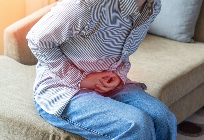 Abdominal pain in young woman with stomachache illness, menstruation cramps, stomach cancer, irritable bowel syndrome, pelvic discomfort, Indigestion, Diarrhea or GERD (gastro-esophageal reflux disease)