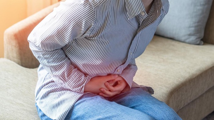 Abdominal pain in young woman with stomachache illness, menstruation cramps, stomach cancer, irritable bowel syndrome, pelvic discomfort, Indigestion, Diarrhea or GERD (gastro-esophageal reflux disease)