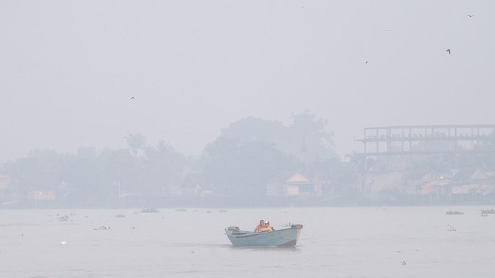 Sejumlah pelajar berangkat sekolah menggunakan perahu tradisional melewati kawasan yang diselimuti kabut asap di Sungai Ogan, Palembang, Sumatera Selatan, Kamis (13/8/2026). Kabut asap tersebut merupakan dampak dari kebakaran hutan dan lahan (Karhutla) yang terjadi di berbagai Kabupaten di Provinsi Sumatera Selatan. ANTARA FOTO/Nova Wahyudi/YU