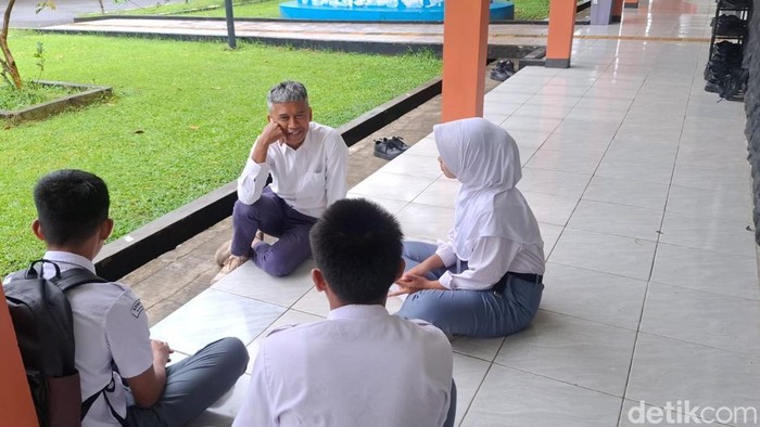 Guru SRMA 12 Bogor Iksan Cahyana saat berbincang dengan siswa.