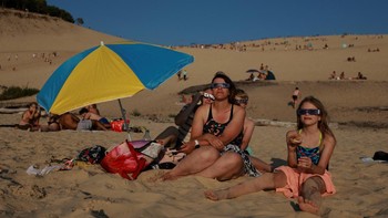 Momen spektakuler gerhana matahari sebagian menarik perhatian warga di Bukit Pasir Pilat, La Teste-de-Buch dekat Arcachon, Prancis, pada 12 Agustus 2026. Fenomena langit tersebut menjadi tontonan istimewa bagi masyarakat yang datang untuk menyaksikannya. REUTERS/Stephanie Lecocq