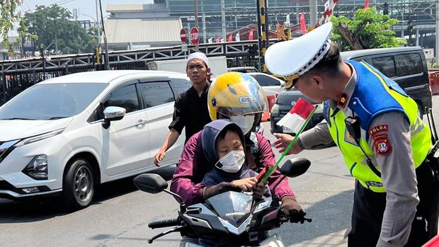 Polantas di Kota Bekasi menyapa pengendara ojol hingga angkot dan membagikan bendera Merah Putih, Kamis (13/8/2026).
