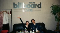 Rachel Cia dan Idom foto bareng sambil duduk di sofa dengan latar belakang tulisan Billboard Live Tokyo. (Foto: dok Instagram rchelcia)