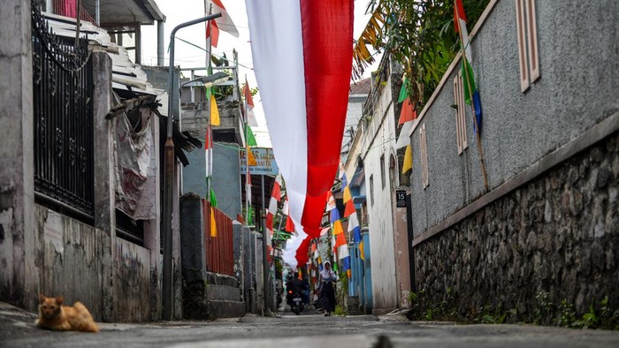 Warga melintas di bawah bentangan dekorasi kain merah putih di Sukanegla, Cicaheum, Bandung, Jawa Barat, Rabu (12/8/2026). Karang Taruna di Sukanegla mendekorasi jalan di permukiman padat tersebut dengan membentangkan kain merah putih sepanjang 150 meter secara swadaya yang digelar dalam rangka menyambut HUT ke-81 Republik Indonesia. ANTARA FOTO/Raisan Al Farisi/wsj.