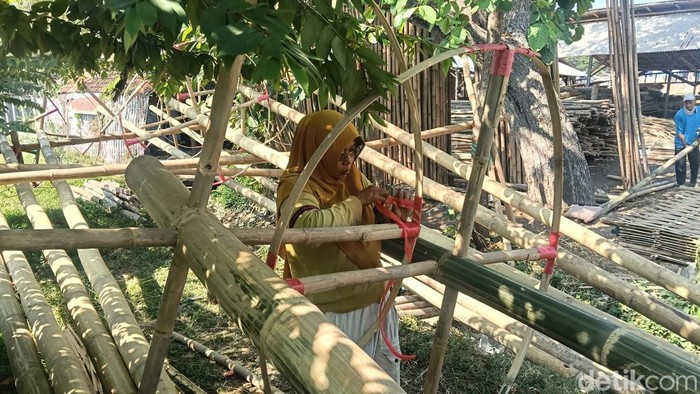 Susi sedang mengikat salah satu bagian di panjat pinang.