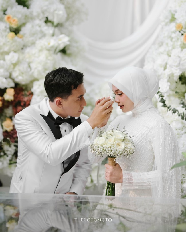 Di momen sakral, hijab clean minimalis menjadi pilihan Dea Annisa, memberikan kesan suci dan anggun. Penampilannya yang bersinar ini berpadu serasi dengan dekorasi pernikahan bernuansa putih oleh @sistadecoration @sistawedding. Foto: Dok. Instagram @deaaannisa.