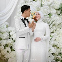 Berpose memamerkan cincin, Dea Annisa mengenakan hijab clean yang sleek, selaras dengan gaun pengantin putih yang elegan dari @irenedanielle. Gaya minimalis ini menunjukkan keanggunan seorang pengantin Muslimah modern. Foto: Dok. Instagram @deaaannisa.