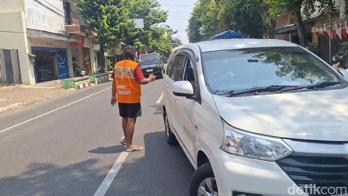 Seorang jukir memberi aba-aba kendaraan di. Kota Pekalongan, Jumat (14/8/2026).