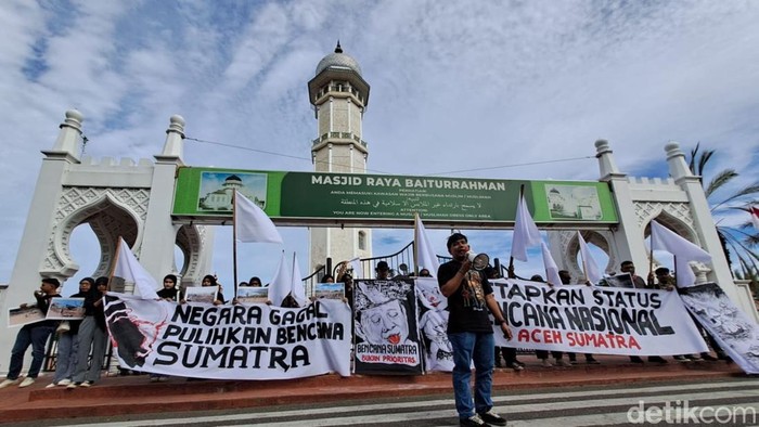 Aksi masyarakat sipil menuntut ditetapkan bencana nasional di depan Masjid Raya Baiturrahman, Banda Aceh.