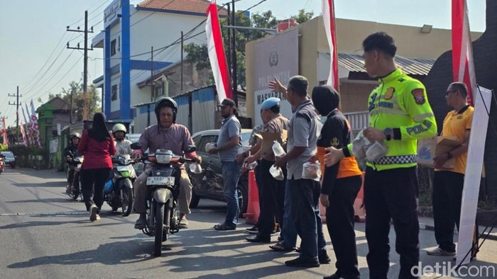 Pembagian paket nasi Jumat berkah oleh polisi di Sidoarjo.